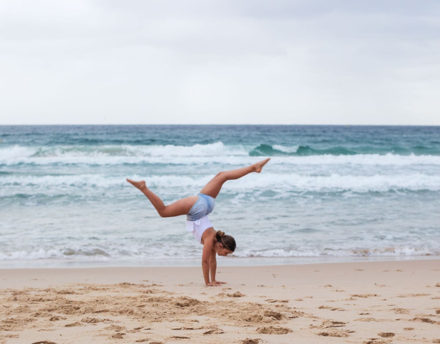 Daughter doing handstand on the beach, playful and fun during a motherhood session taken by A Lasting Impression Photography.