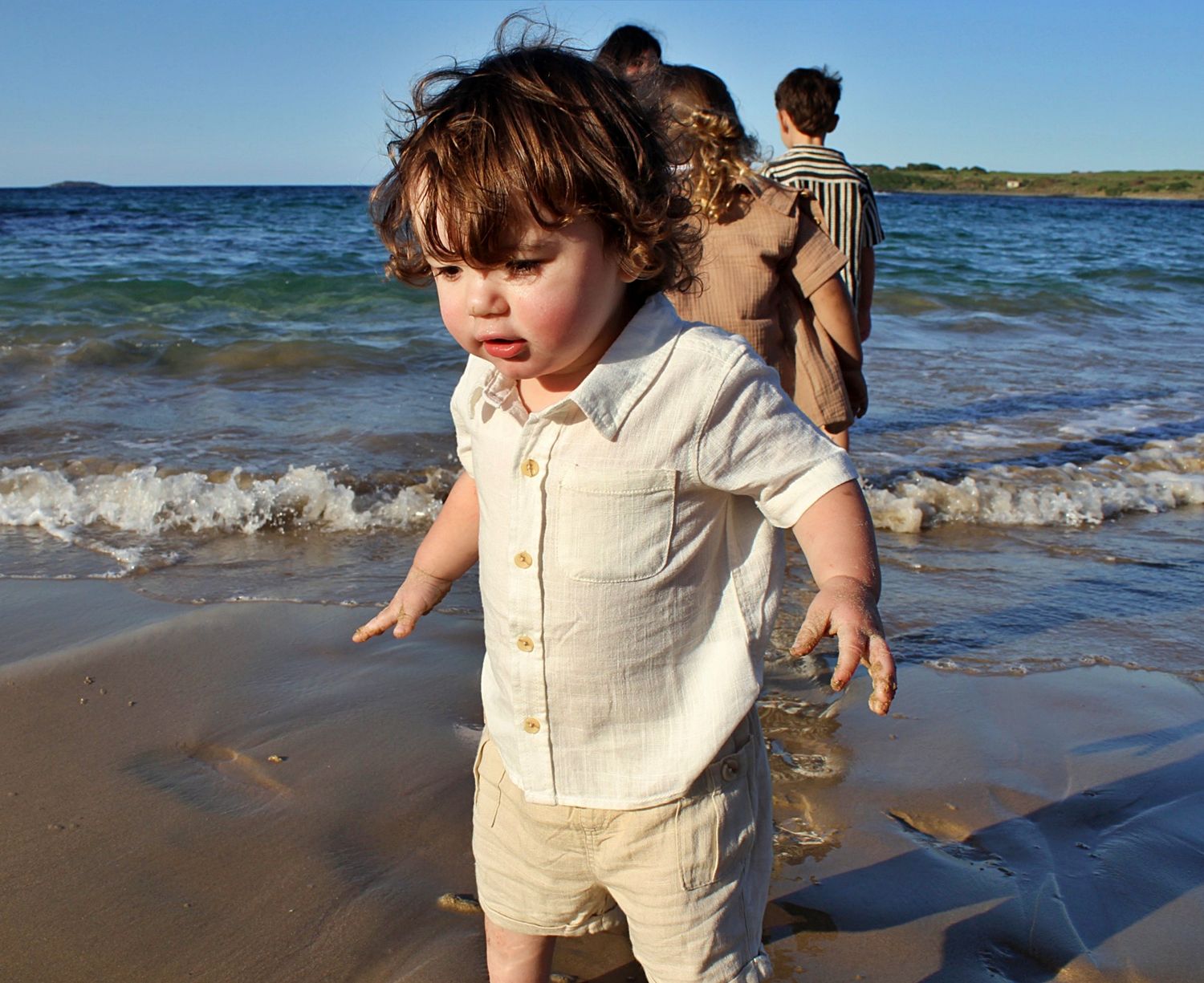 Solo candid portrait of son walking along the beach during a motherhood session.