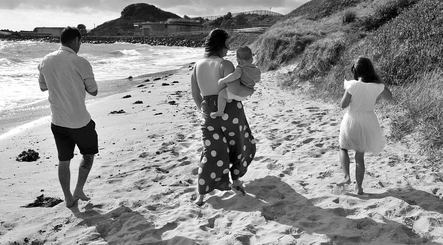Candid family portraits by the sea in the Illawarra, documenting genuine moments and timeless beachside connection.