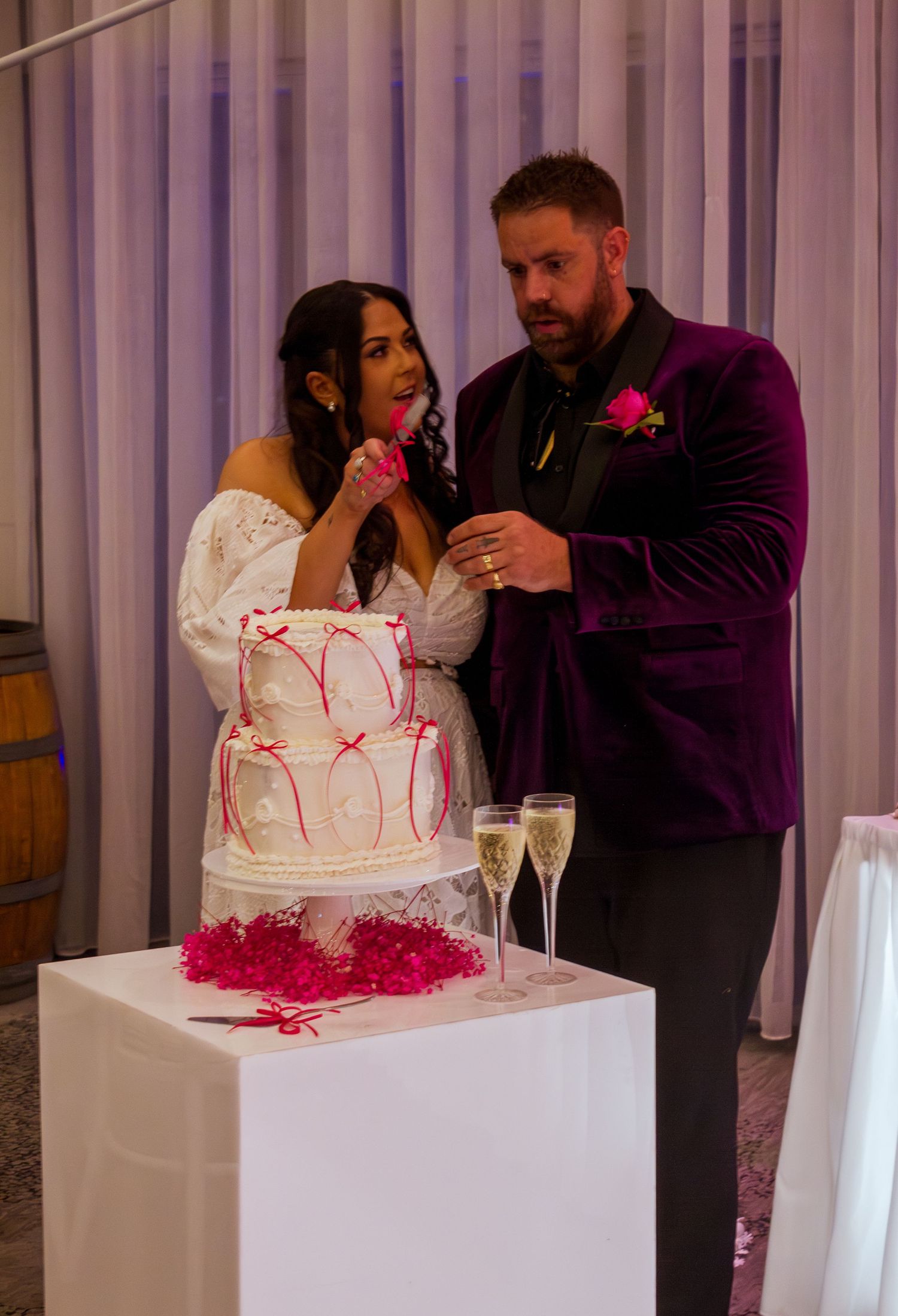 Bride and groom cutting their wedding cake together during the reception celebration.