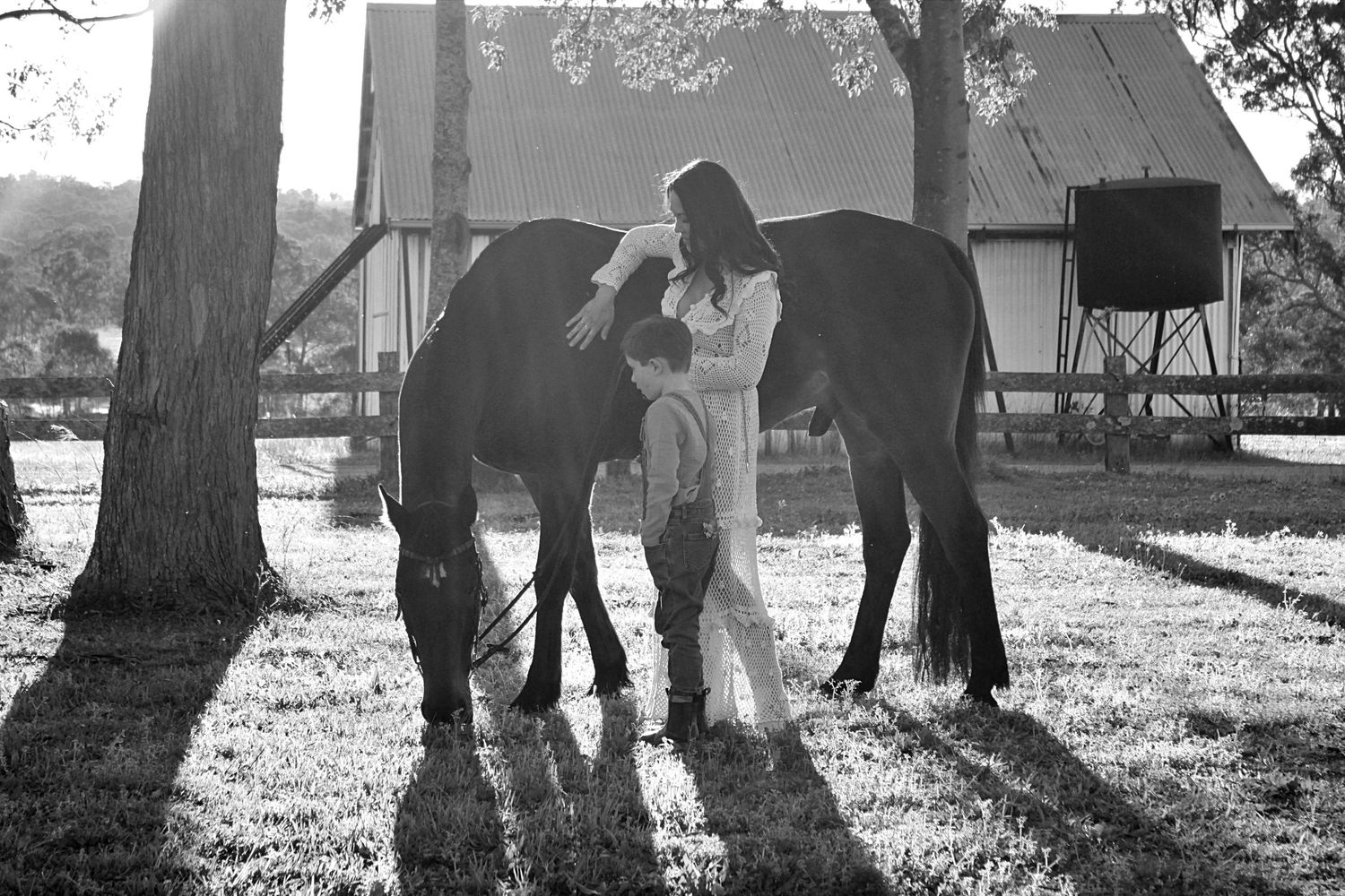 Mother and son gently interacting with a horse outdoors during a family session