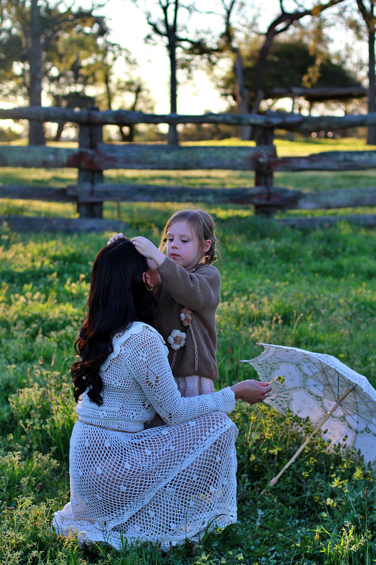 Sweet moment of daughter decorating mum’s hair with flowers during a family session