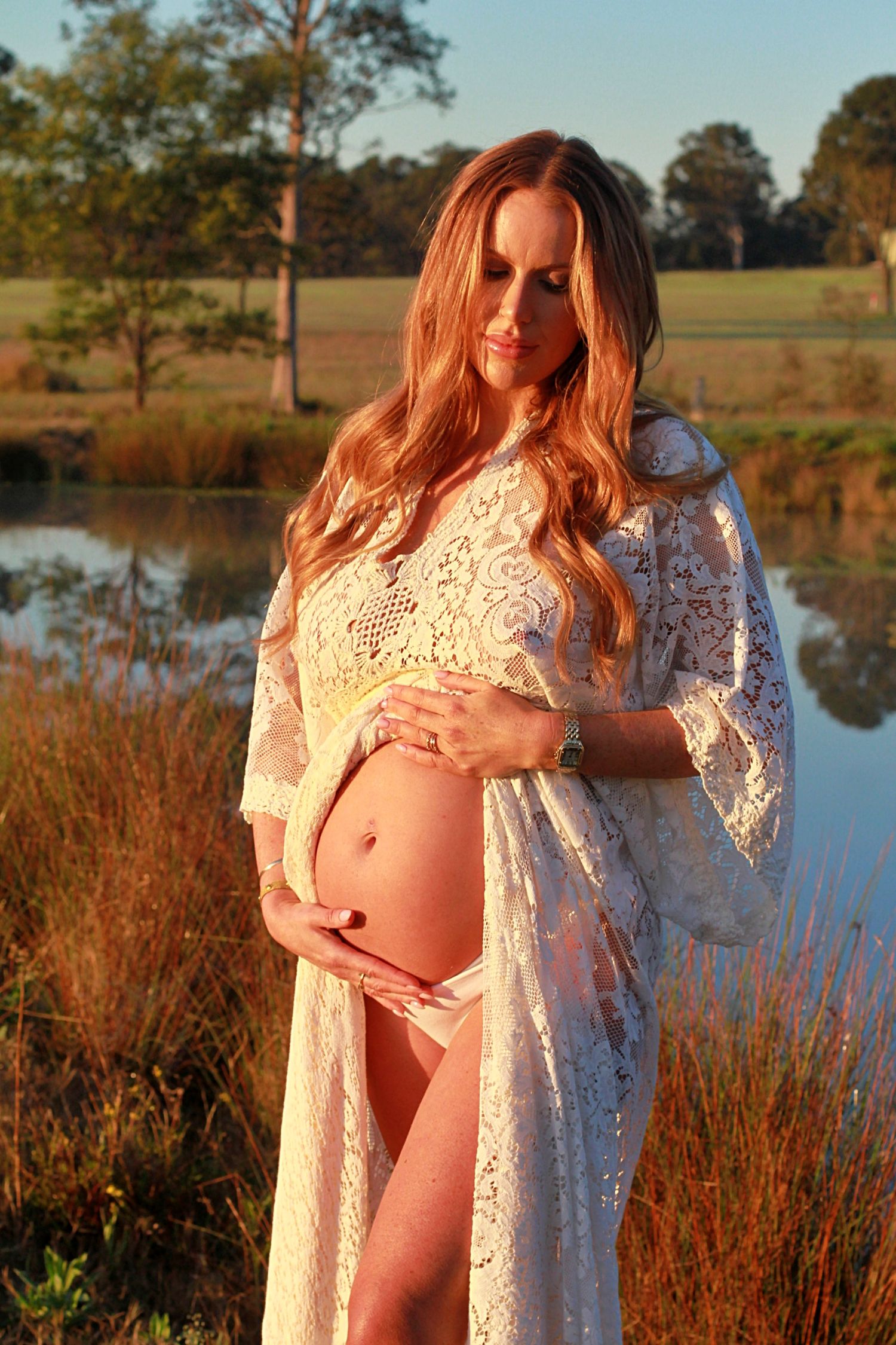 Mumma to be during sunrise lifestyle maternity sessions holding her belly.