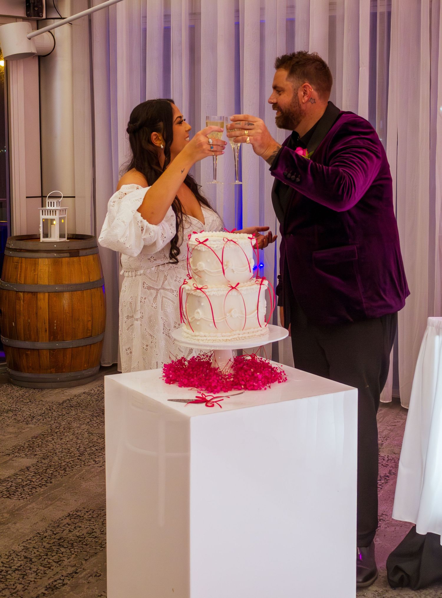 Bride and groom cutting their wedding cake together during the reception celebration.