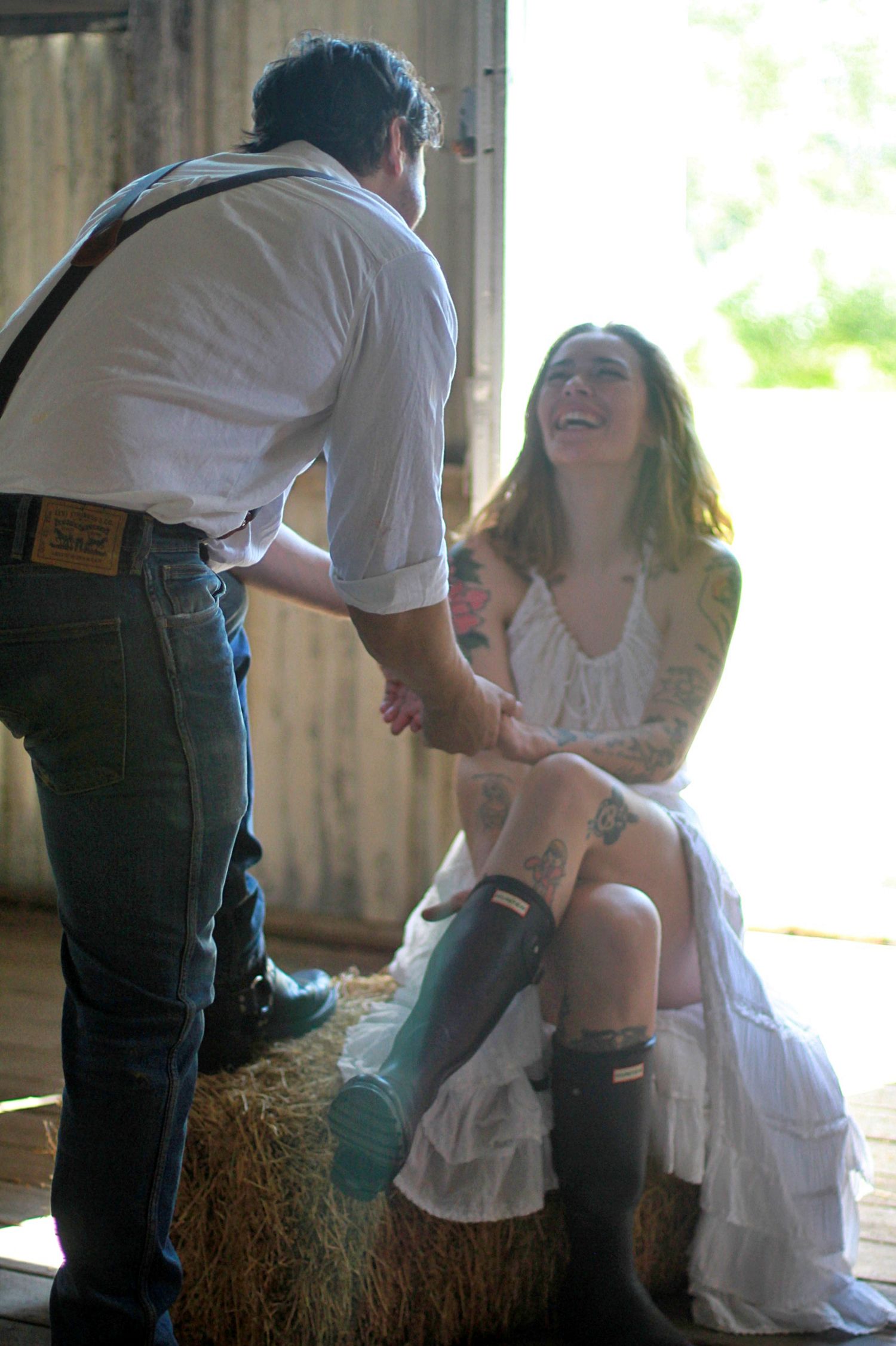 Romantic couple portrait with geniuine laughs and hands intertwined