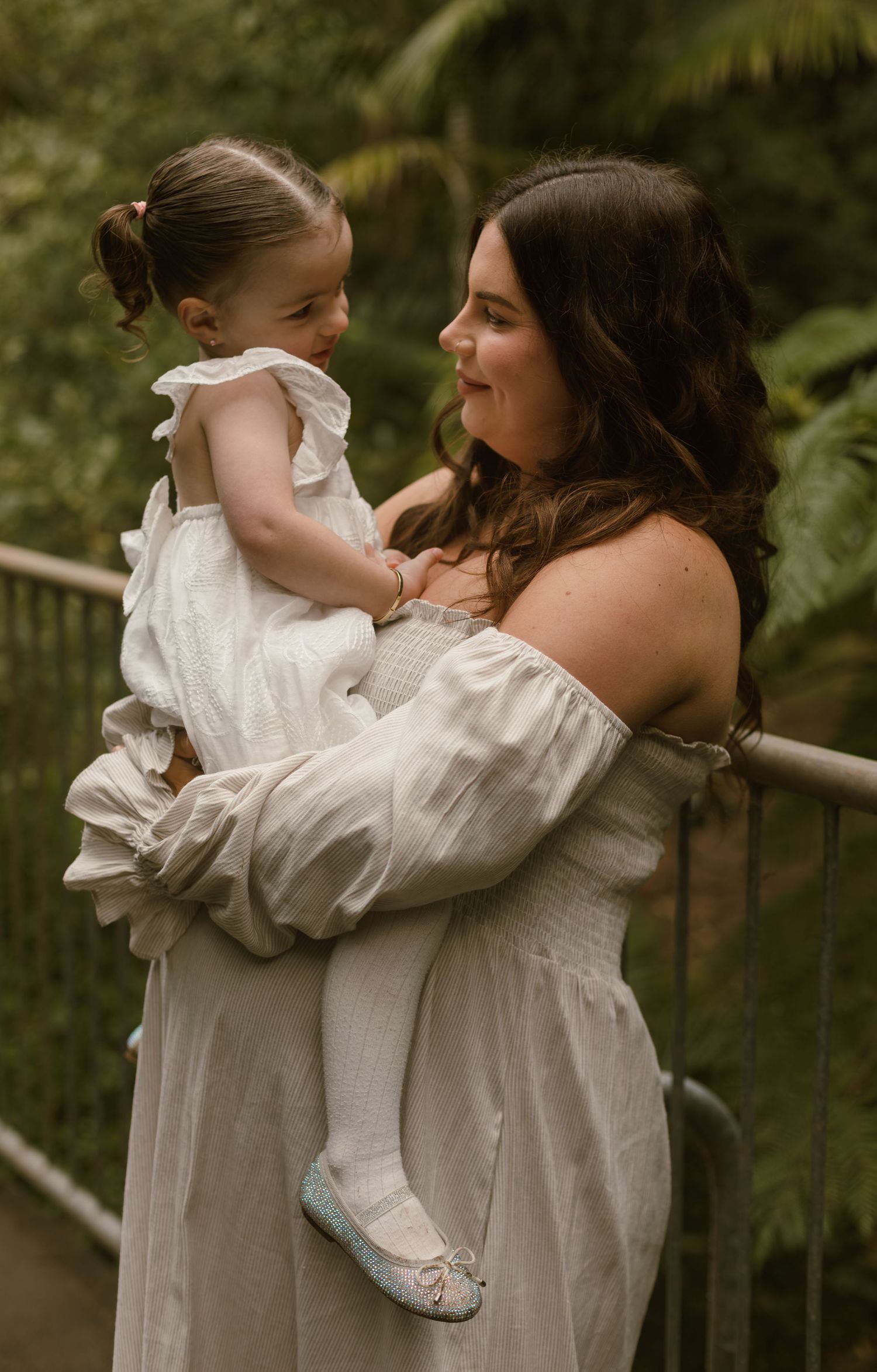 Pregnant mum holding her young daughter during an outdoor family maternity photography session.