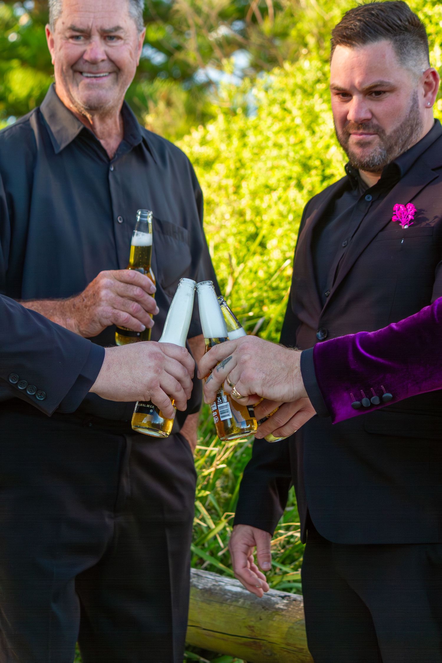 Groomsmen cheering beers together after the ceremony, celebrating the newly married couple.