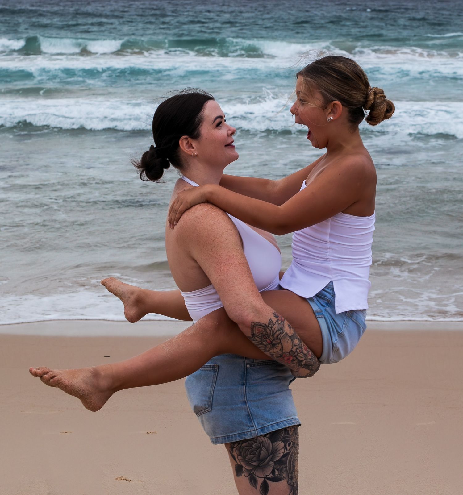 Goofy mother-daughter moment laughing together at the beach during a motherhood session taken by A Lasting Impression Photography.