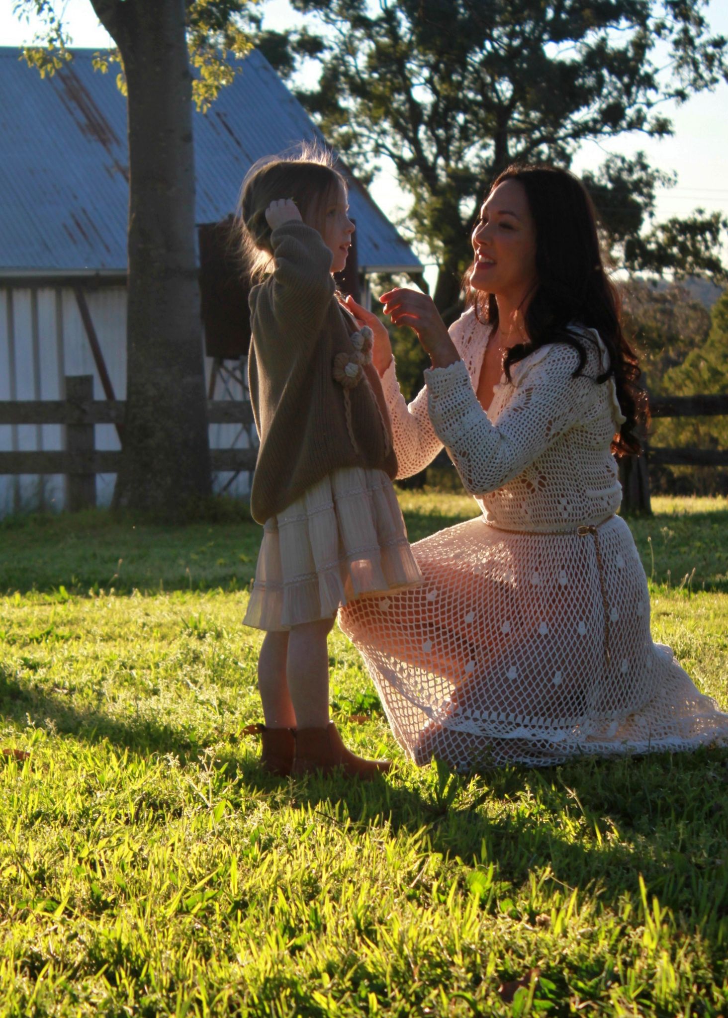 Mum kneeling to connect with her daughter during outdoor family session