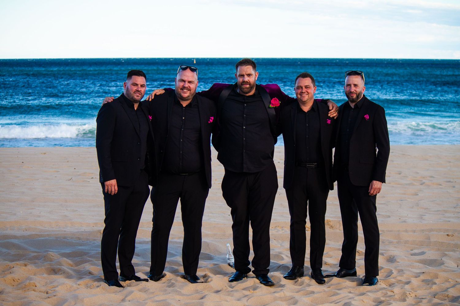 Groom portrait with his groomsmen on the beach after the ceremony.