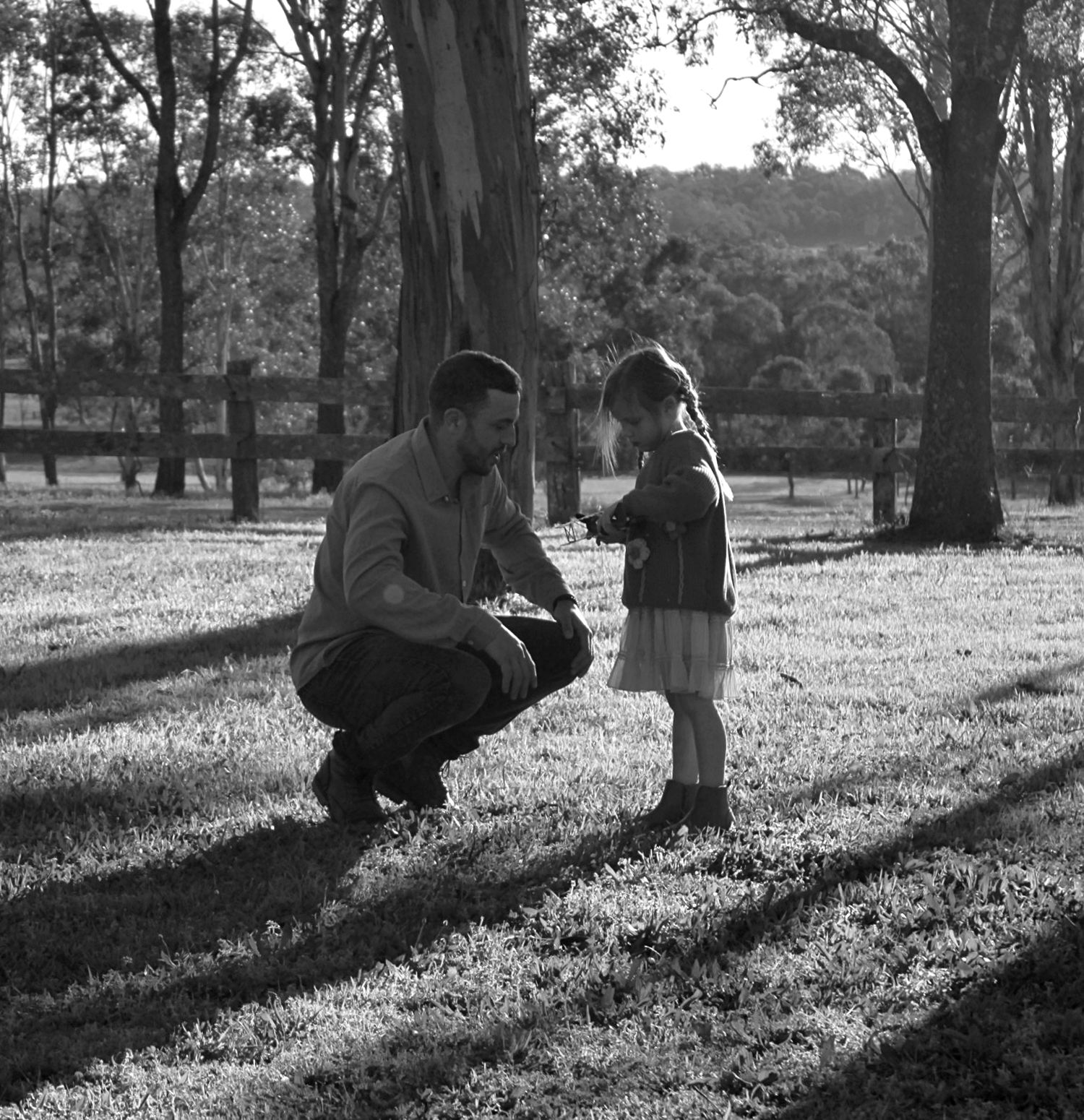 Close up of child smiling next to her an adult outdoors during a family session