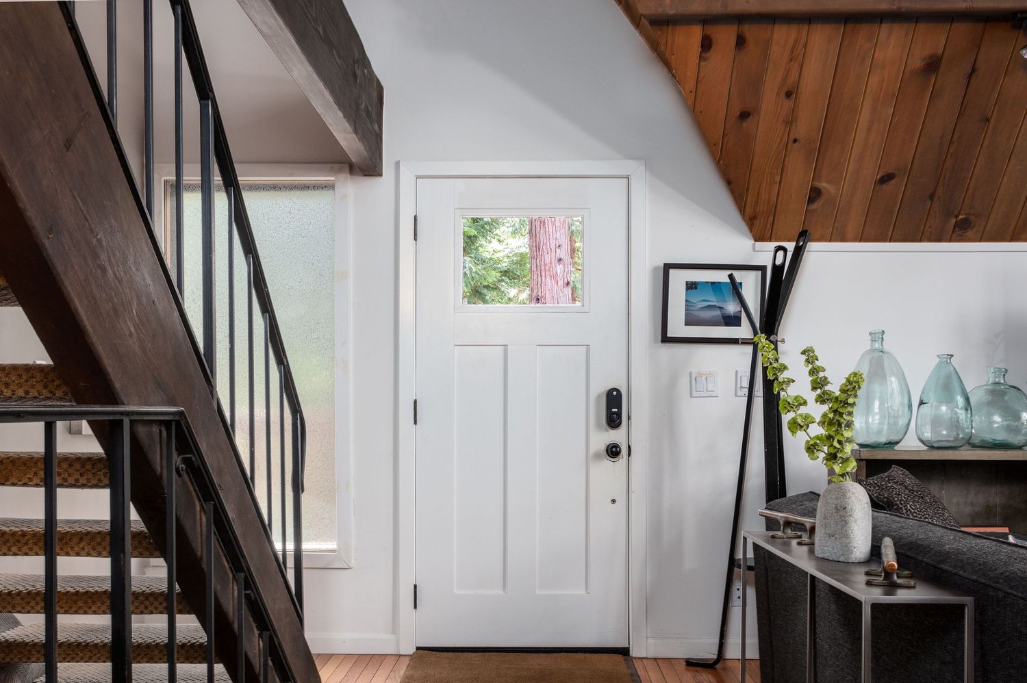 Modern rustic interior with wooden beams, white walls, and natural light streaming through windows.