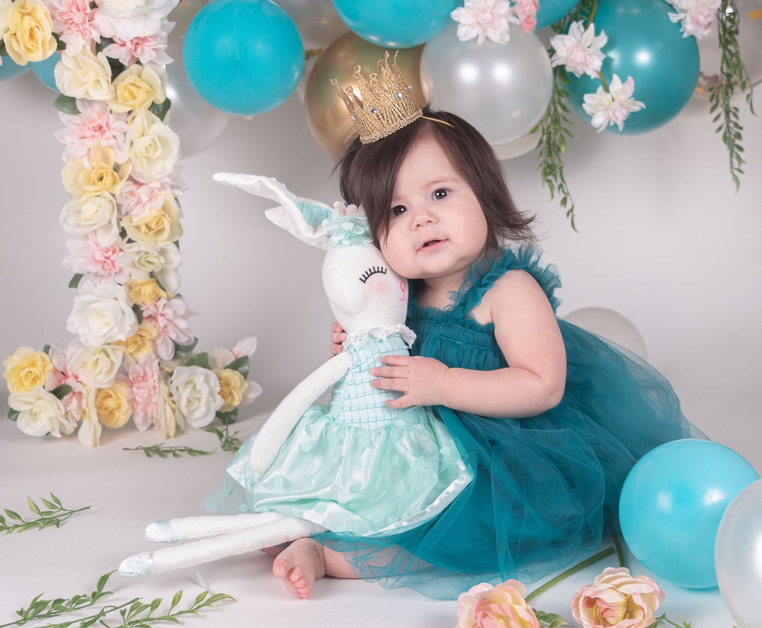 Birthday party scene with turquoise balloons, floral arrangements, and elegant decorations.