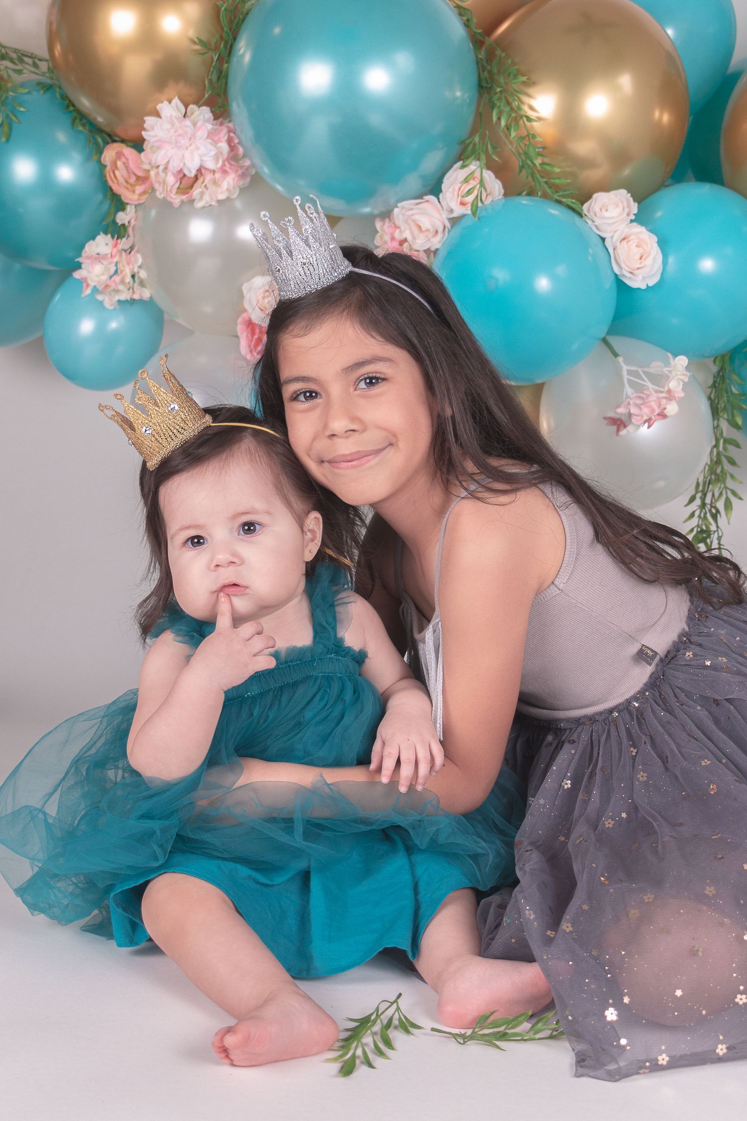 Festive balloon arch with teal and gold balloons creates elegant party backdrop.