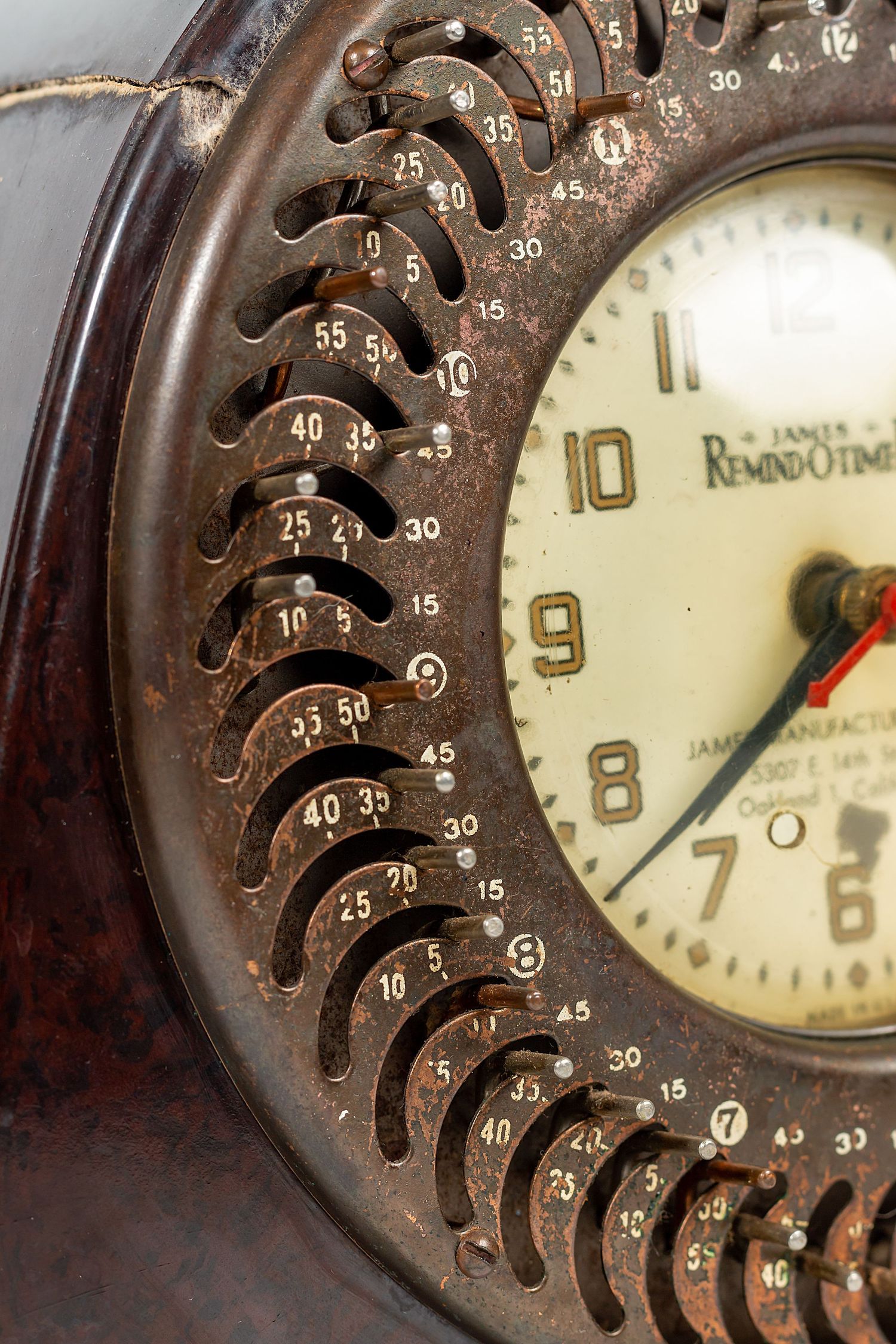 Vintage rotary phone dial with numbered slots and aged patina against cream-colored face.