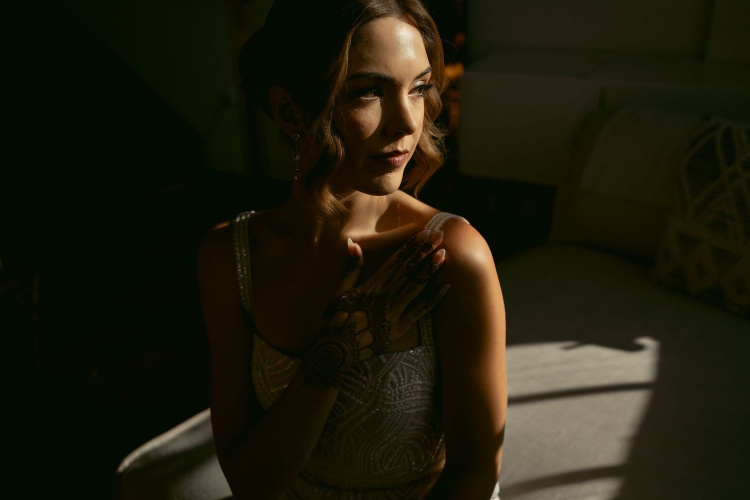 Dramatic portrait with natural light streaming through window creating shadows and highlights.
