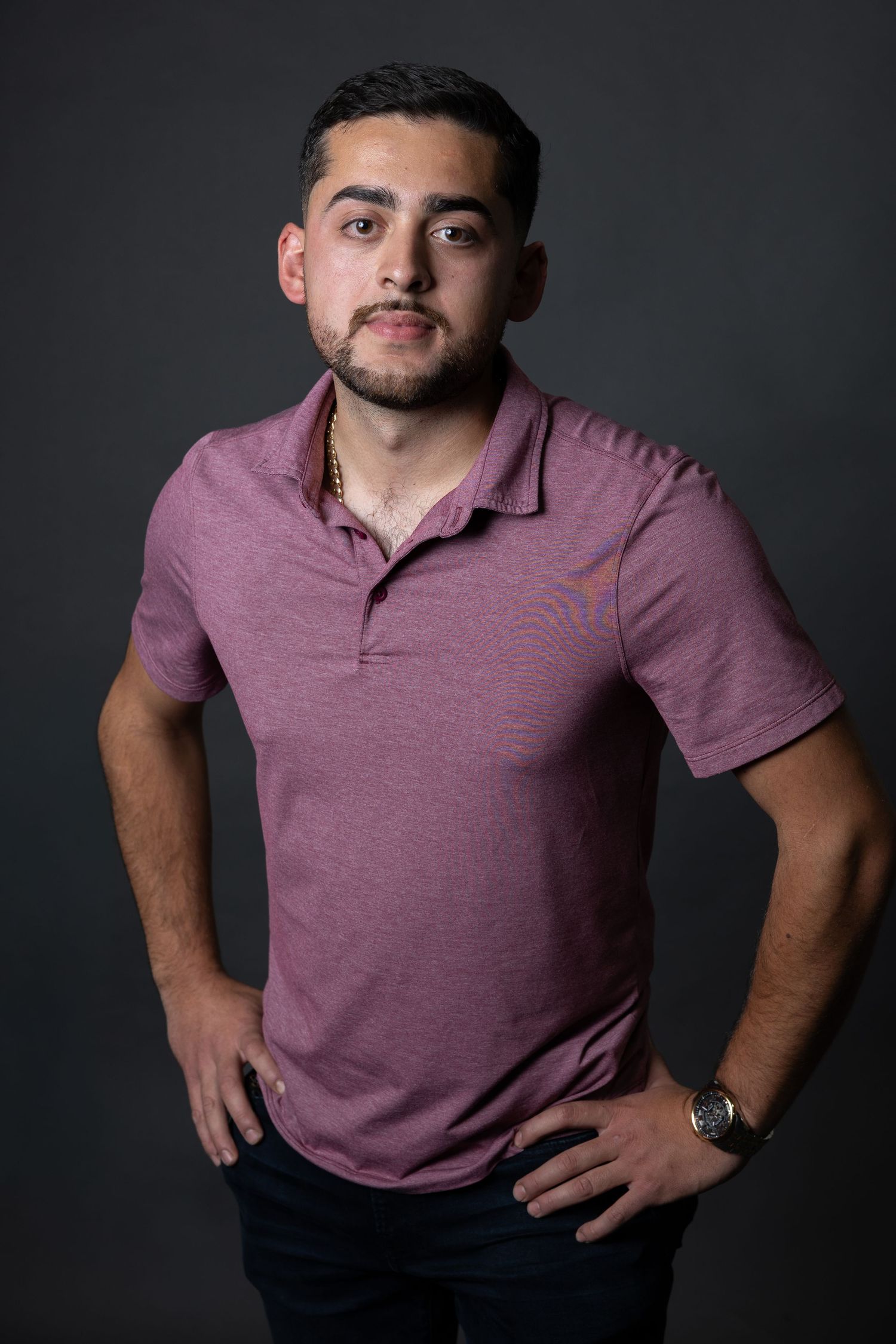 Professional studio headshot of a man against a studio backdrop.
