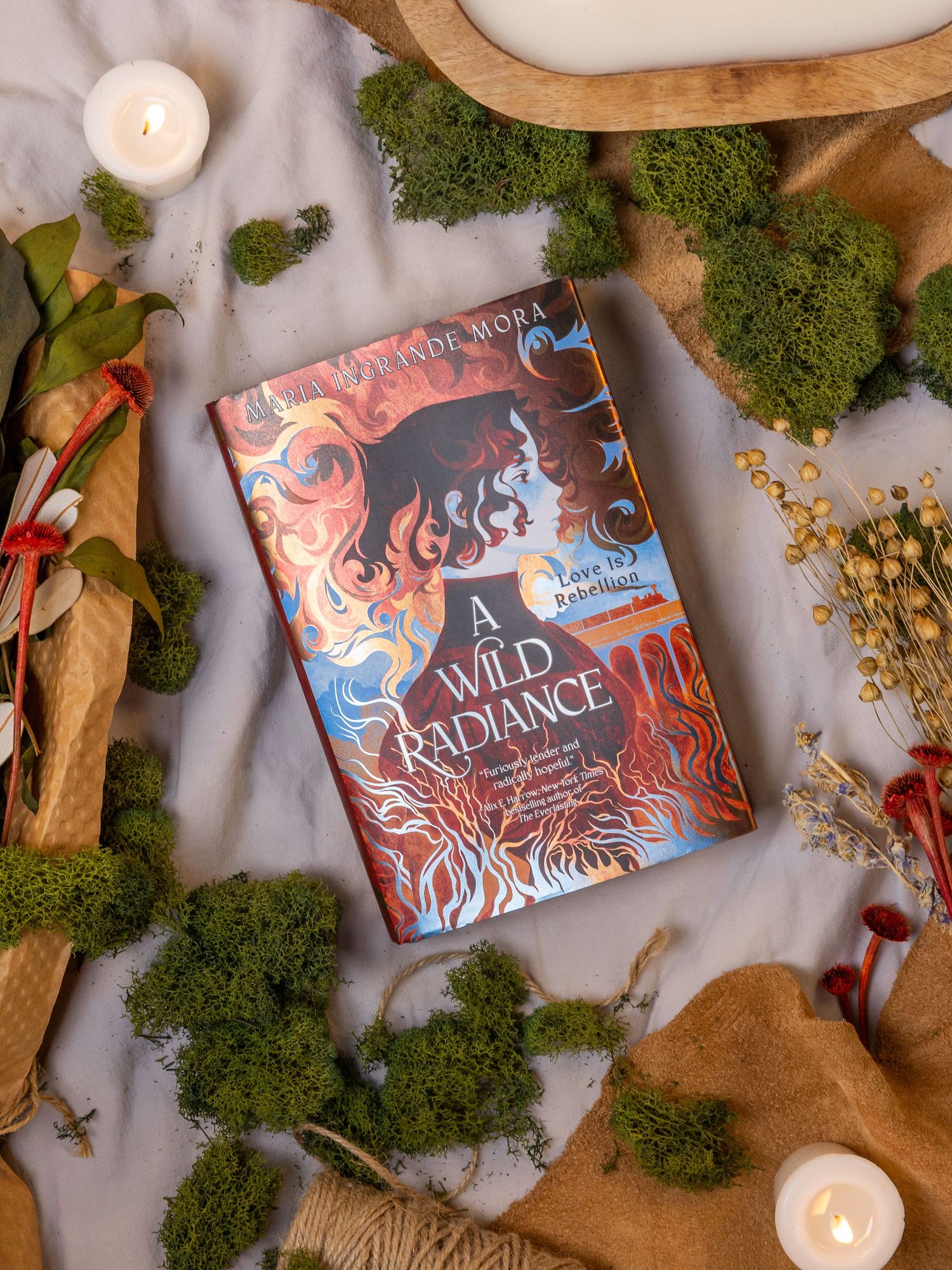 Creative flat lay photograph featuring the book A Wild Radiance by its author.
