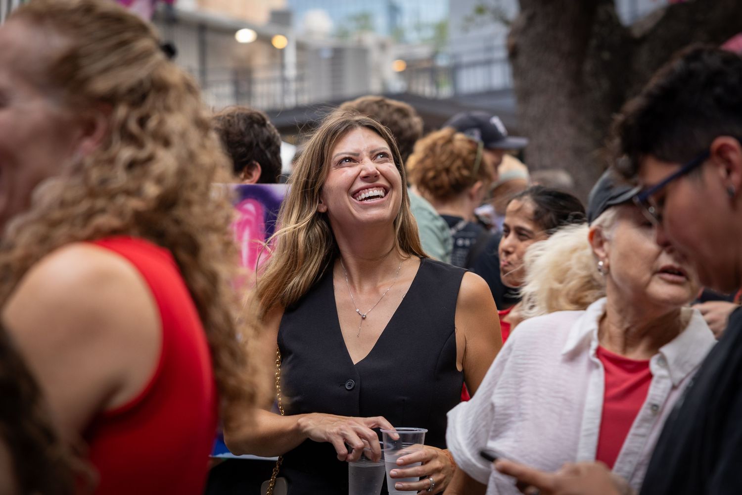 Candid event photograph of a woman smiling in the crowd at a Girls Rock St. Pete event in St. Petersburg, Florida.