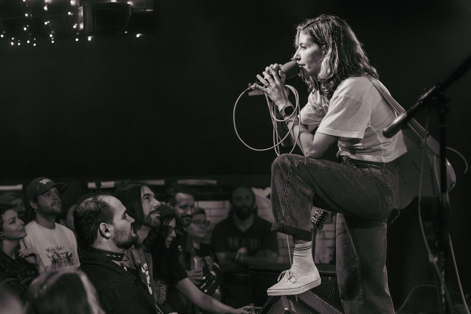 Black-and-white concert photograph of a female singer performing in front of a live audience.