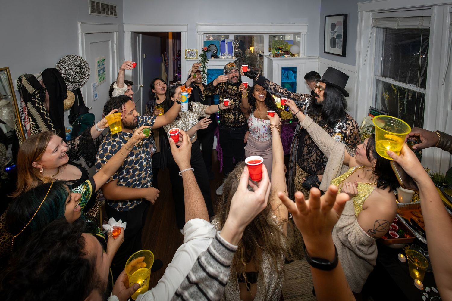 Candid event photograph of friends raising their glasses in a toast during a birthday celebration.