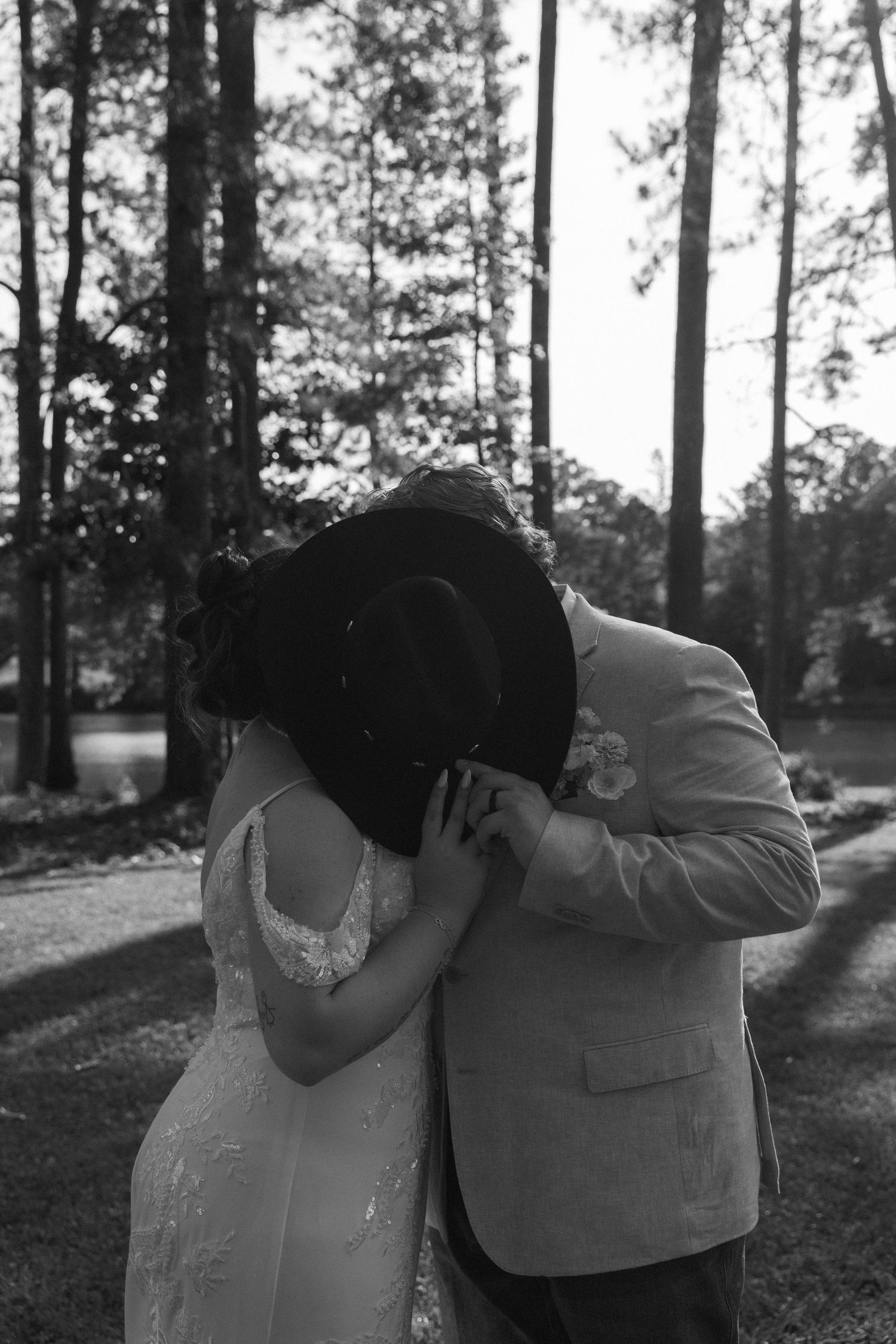 A romantic black and white wedding photo of a couple in a forest setting sharing an intimate moment at their intimate colorado wedding