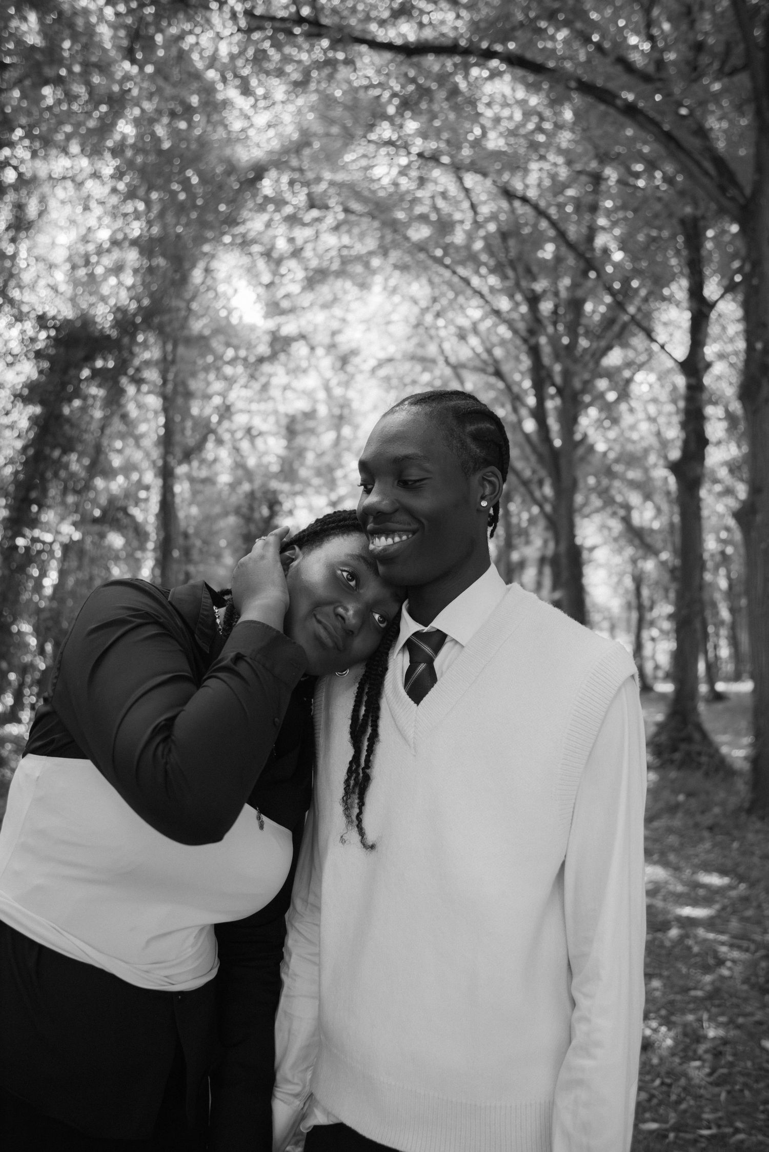 Photographe couple Essonne 91, jeune femme la tête posée tendrement sur l'épaule de son compagnon souriant en forêt
