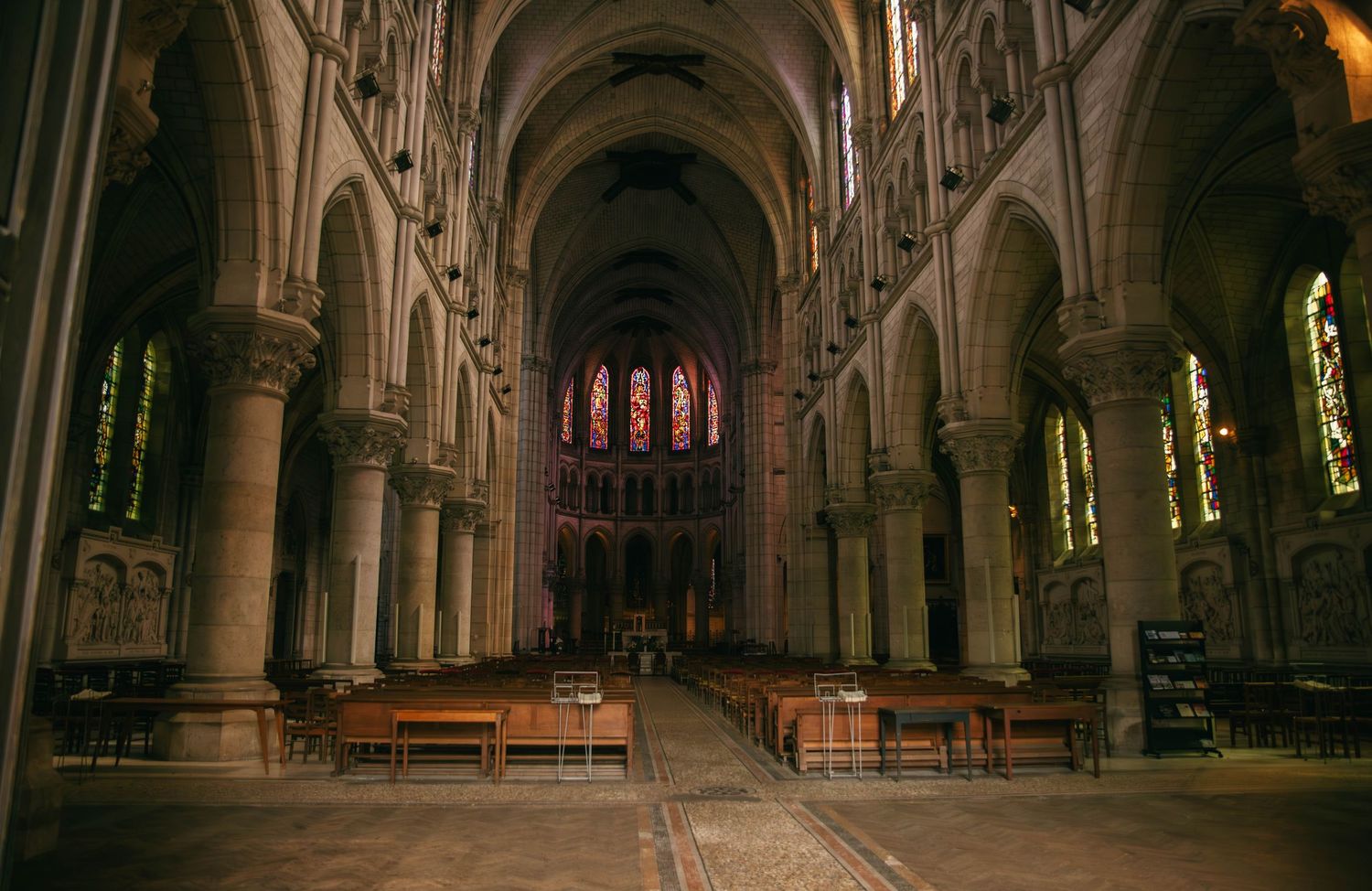 Intérieur majestueux d'une cathédrale d'Orléans lors d'un mariage : nef gothique, vitraux colorés et ambiance solennelle. Photographe 91.