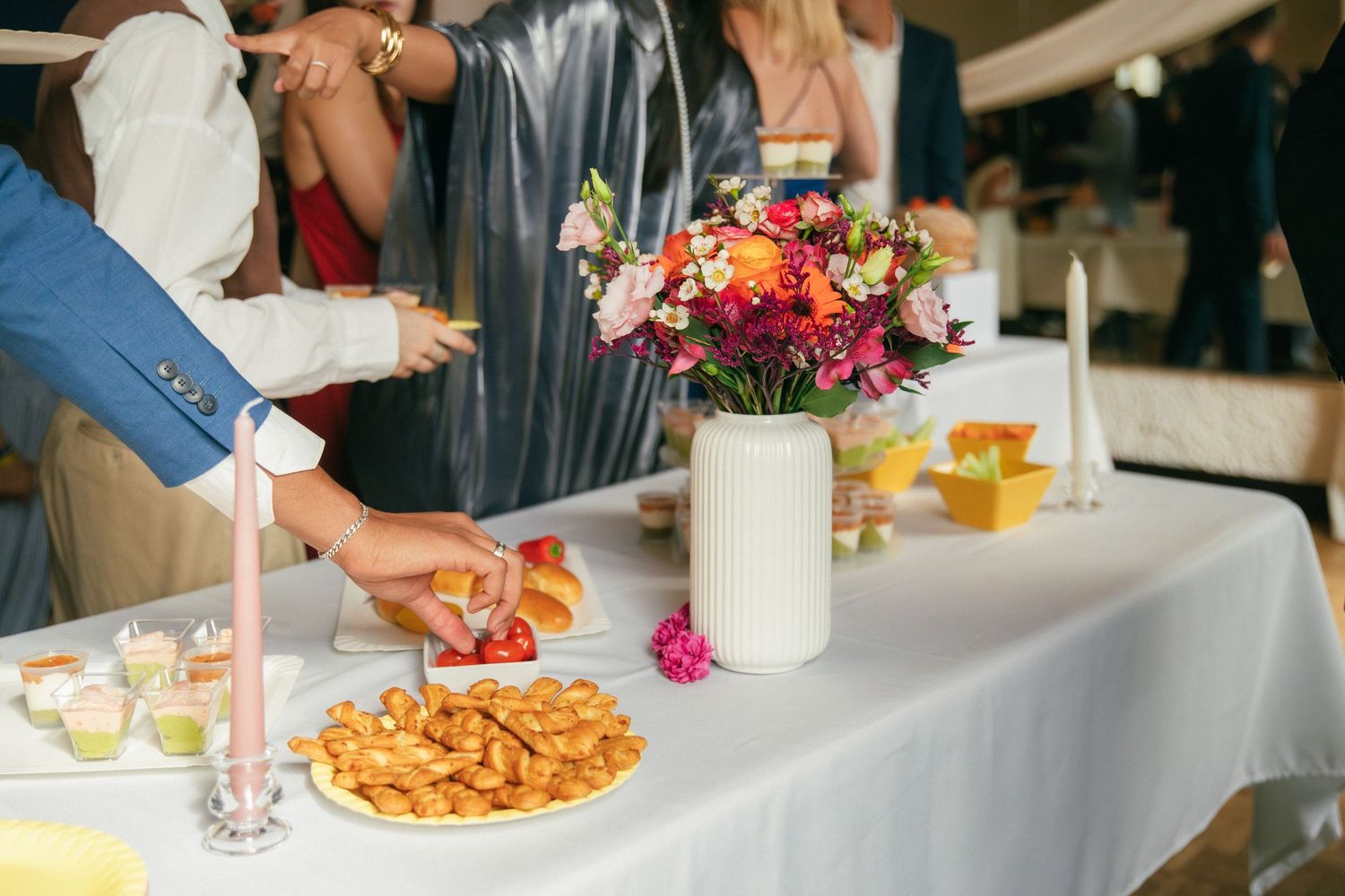 Table de cocktail mariage en Essonne : buffet doré, fleurs colorées et bougies pour une réception élégante. Photographe mariage 91