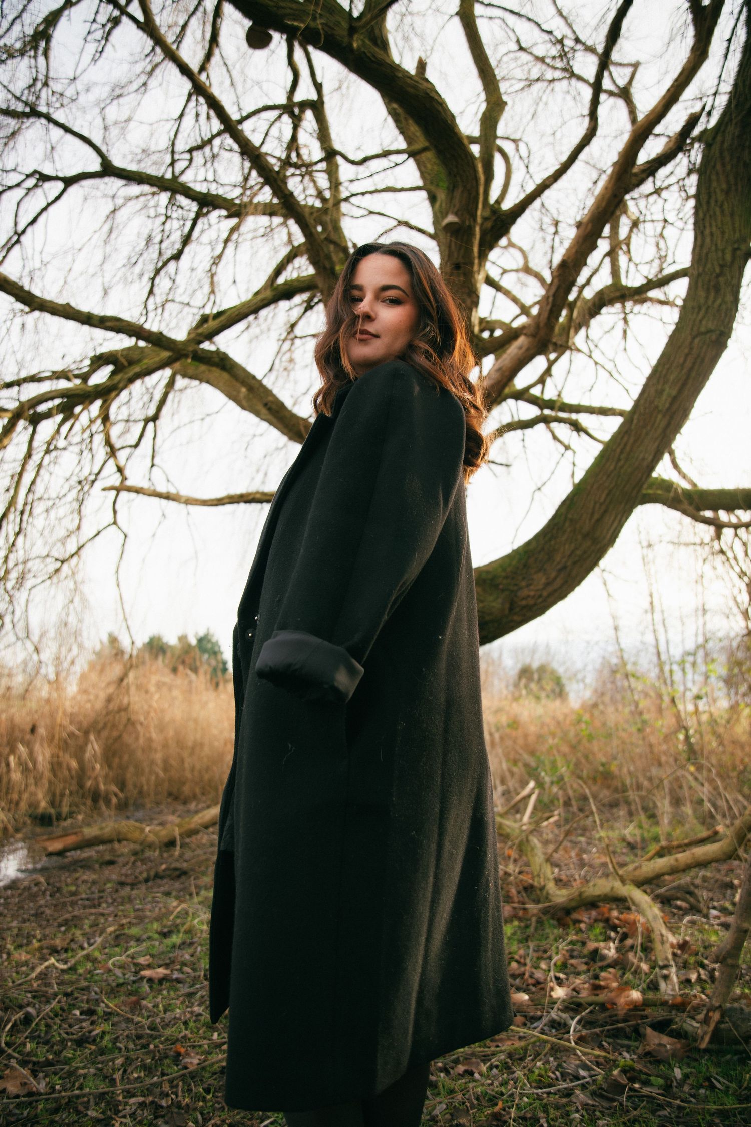 Photographe Essonne 91, portrait de jeune femme au manteau sombre regardant l'objectif, ambiance hivernale