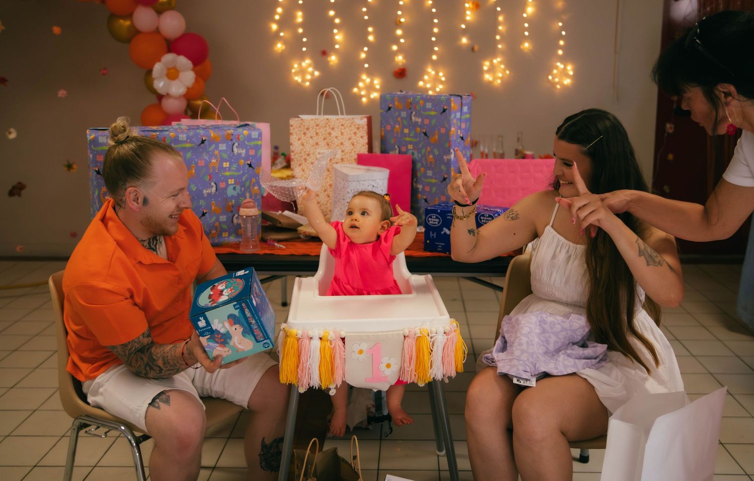 Bébé dans sa chaise haute entouré de cadeaux et de ses parents lors de son premier anniversaire. Reportage famille en Essonne.