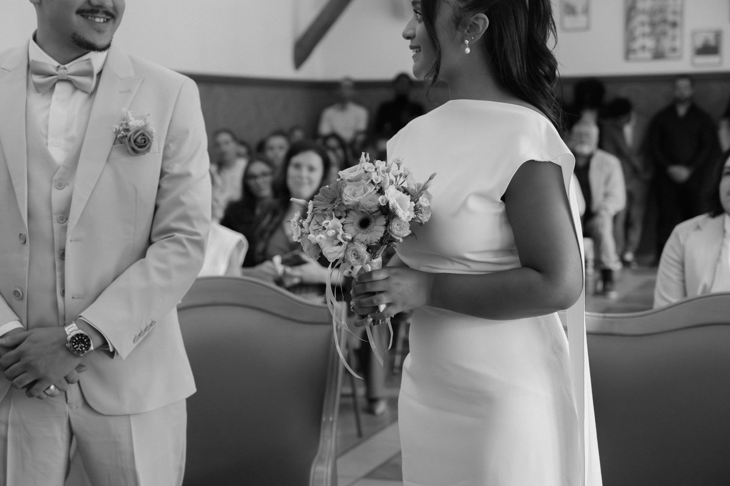 Photographe mariage Essonne 91, mariés face à face lors de la cérémonie civile, mariée au bouquet de fleurs, noir et blanc reportage mariage