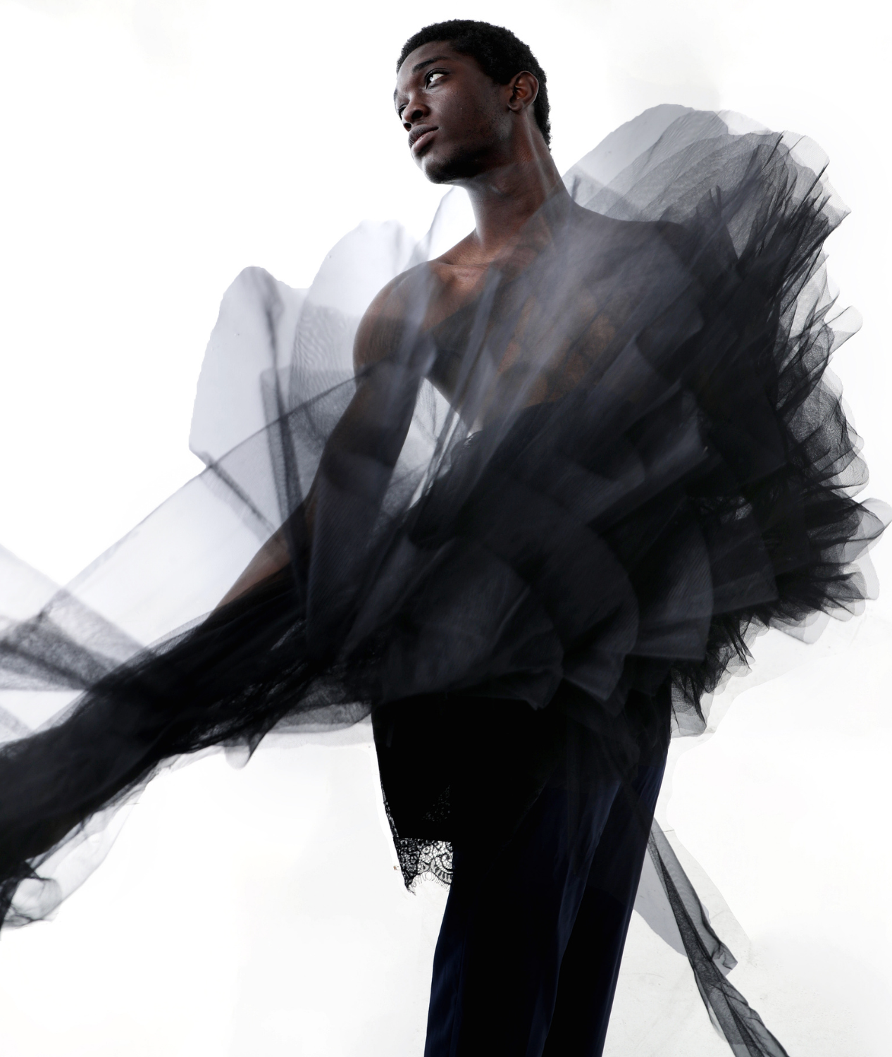 Poised boy with black chiffon clothing surrounding him