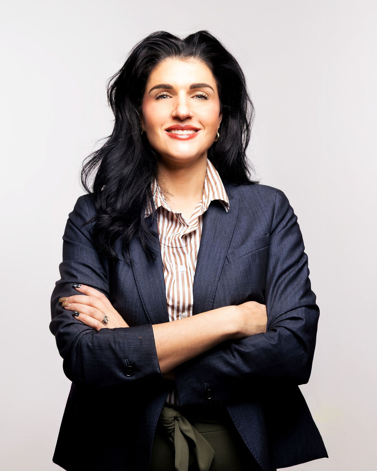 Strong headshot of woman crossing arms in suit