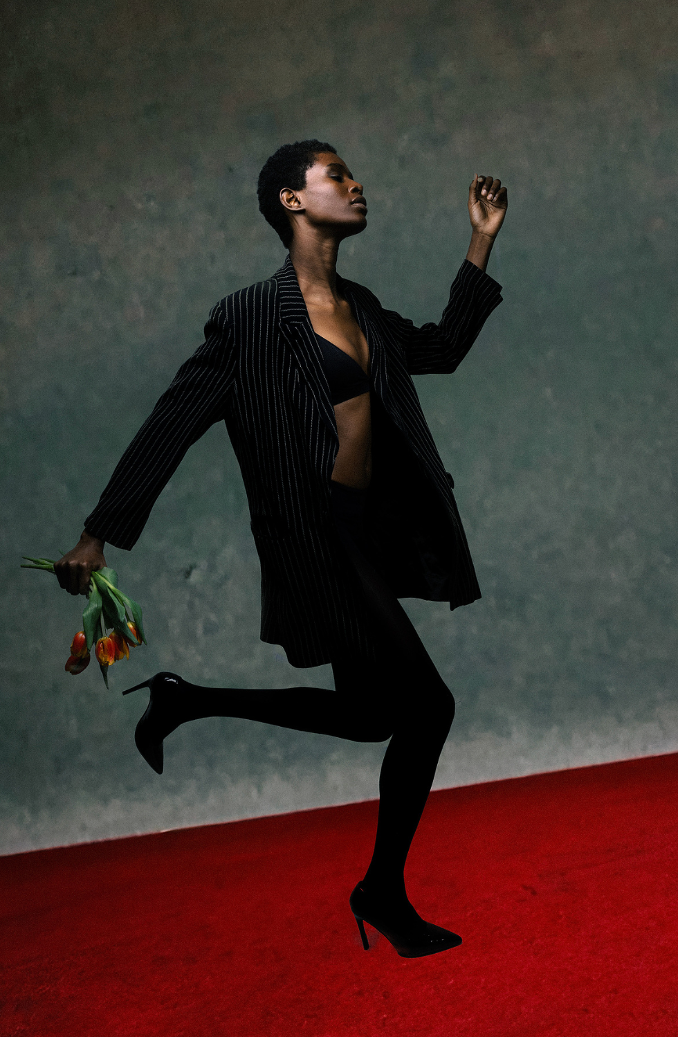 Woman running in editorial style image with flowers in hand