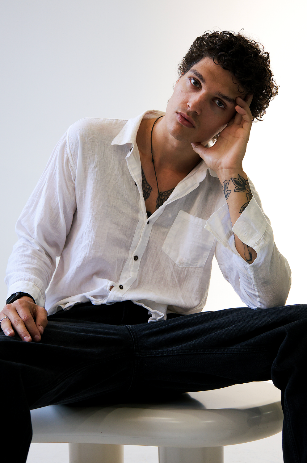 Boy pensively posing, clean button down shirt and black jeans