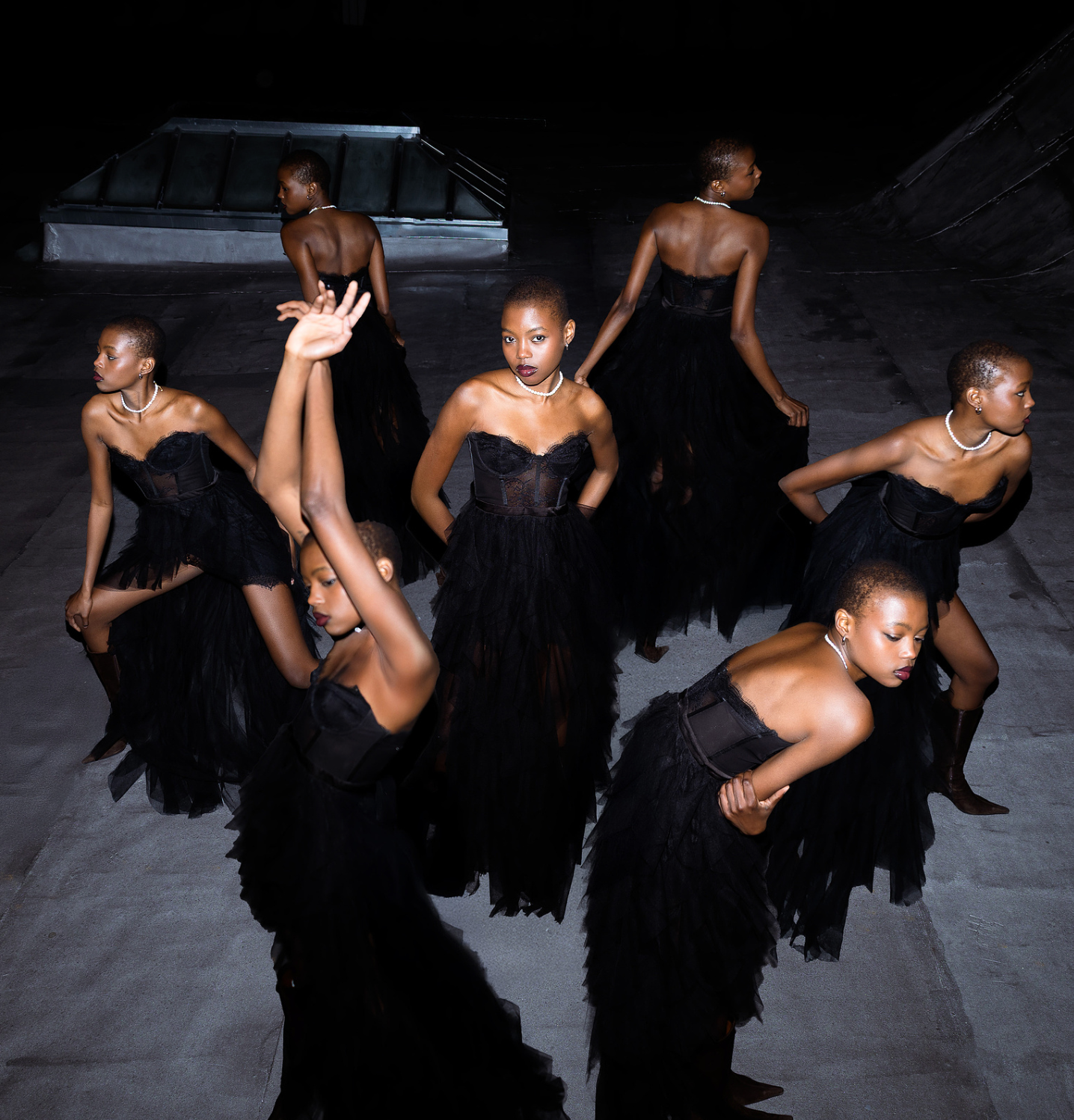 Multiple clones of girl wearing classy elegant black dress and pearls
