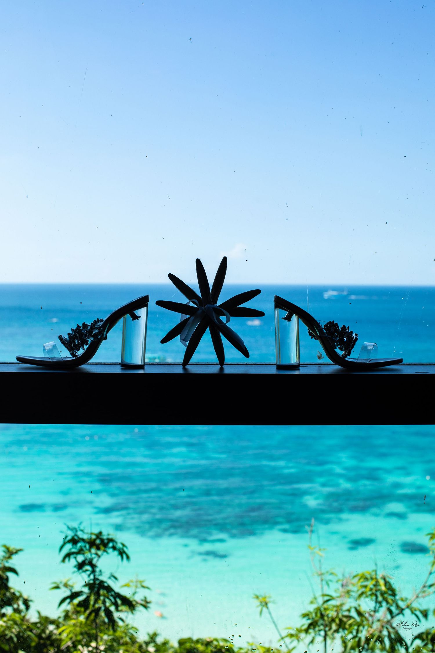 Silhouetted floral centerpiece and candles against stunning turquoise Caribbean ocean backdrop.