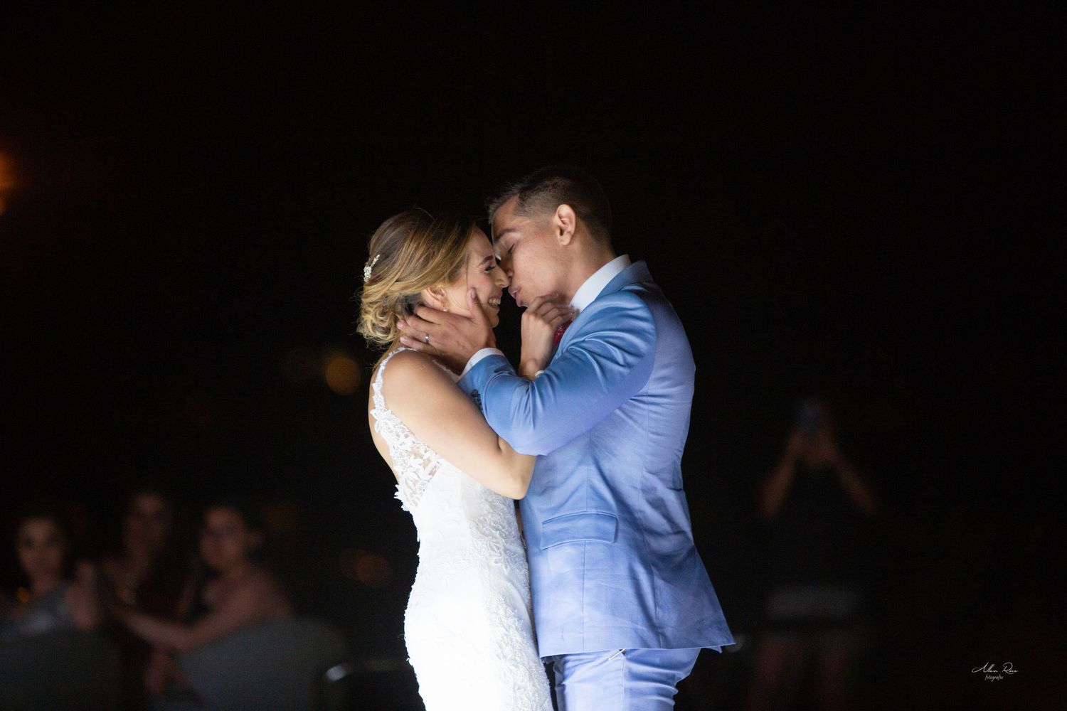 Bride and groom sharing a passionate kiss on the dance floor at their wedding reception.
