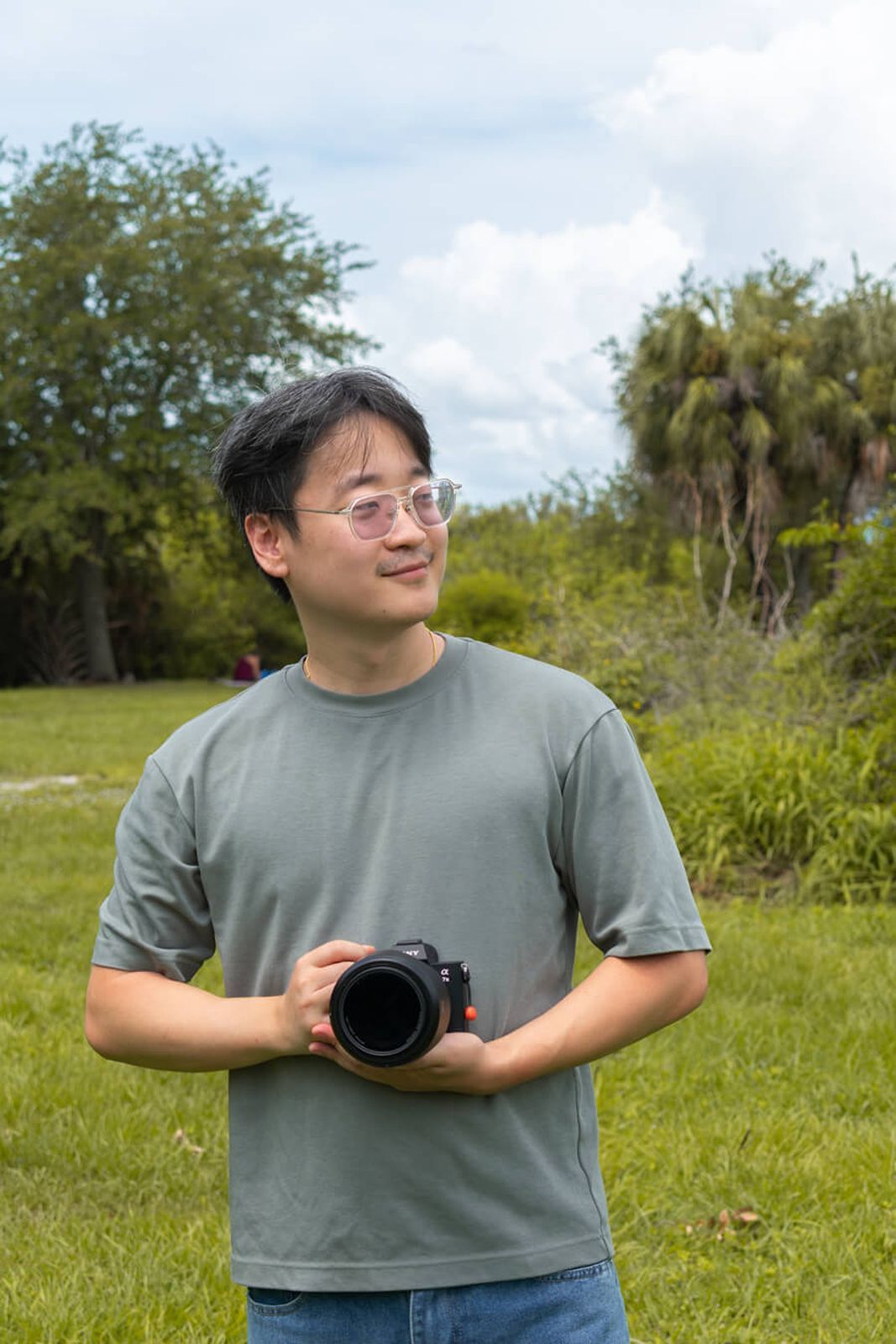 portrait shot holding a camera of sony a7iii with a viltrox 35mm f/1.2 in tampa florida