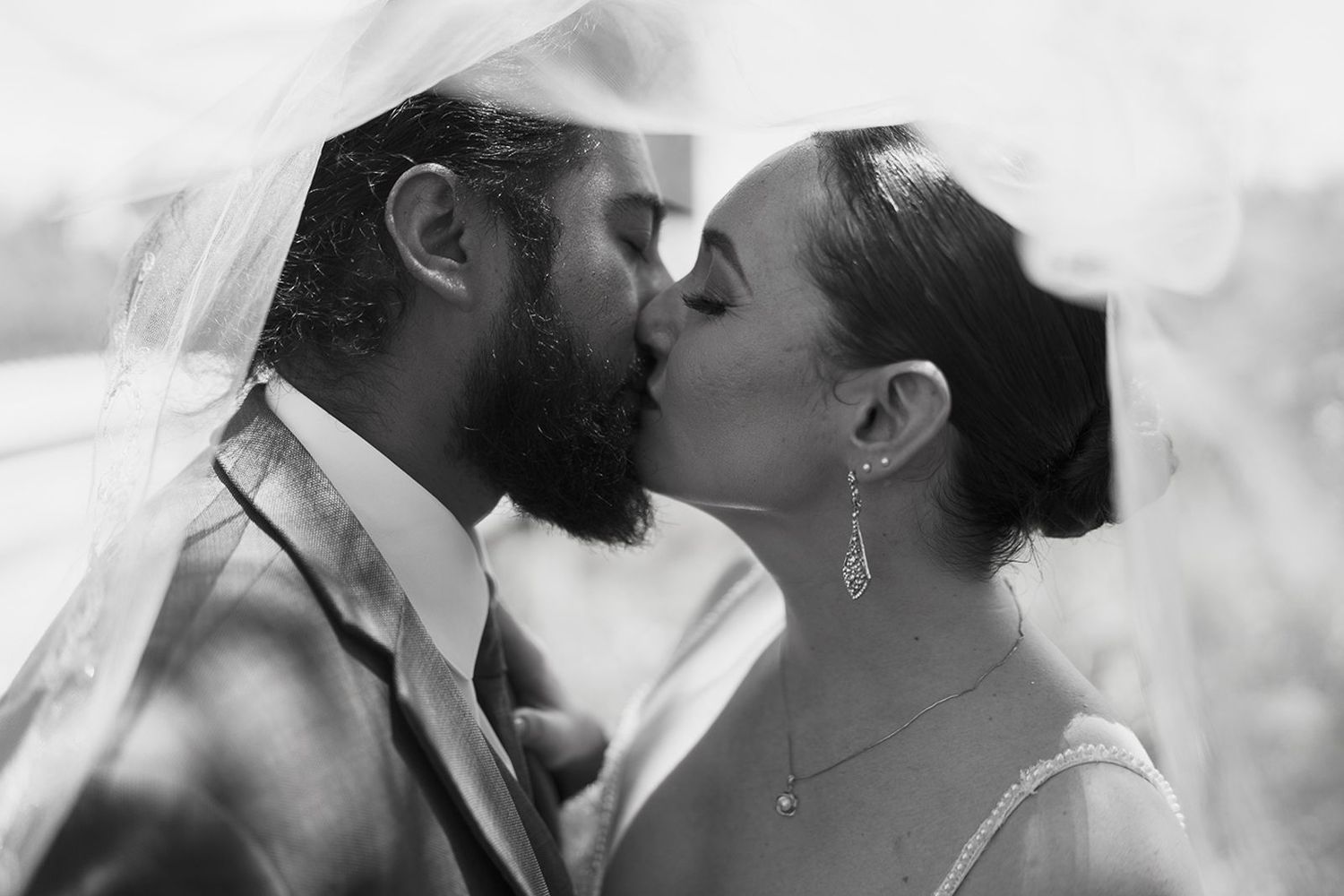 wedding couple kissing under vail black and white james jang photography