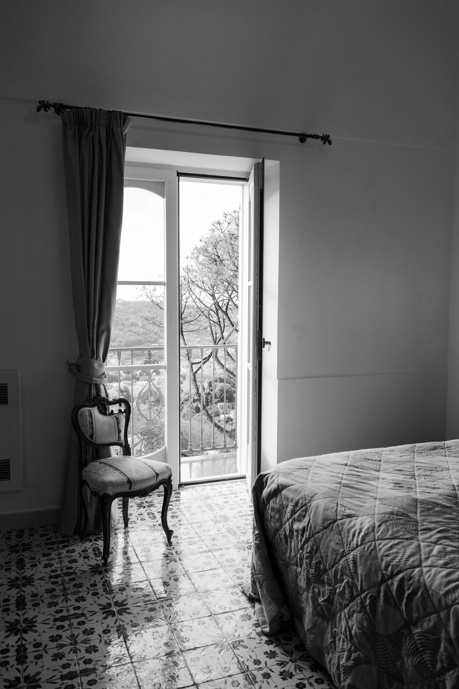Bridal suite at hotel Oasi Olimpia Relais. The room has an elaborate wooden chair and the floor tile has a detailed floral design.