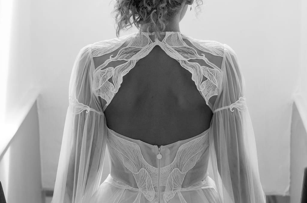 Bridal cape with leaf shaped patterns, back cut out and long sheer sleeves.
