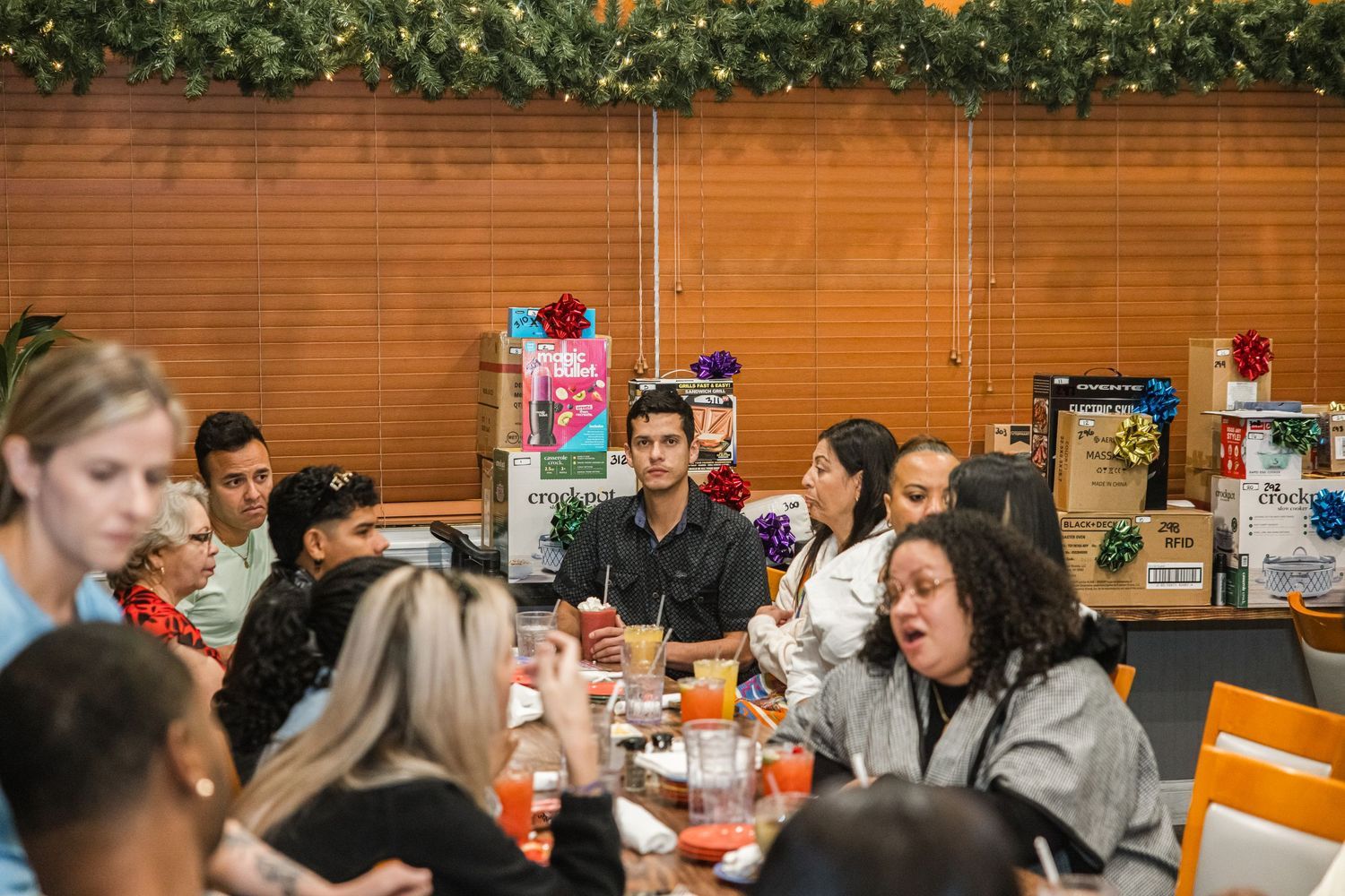 Group of people dining together at festive holiday party with Christmas decorations.