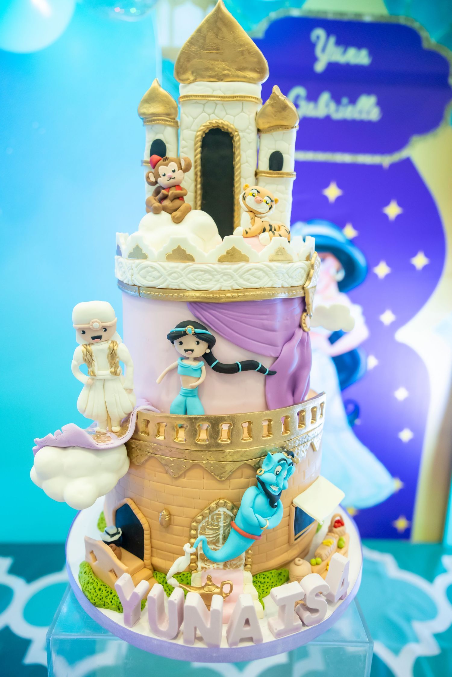 Elaborate two-tier Princess Jasmine Aladdin castle birthday cake with fondant characters for Yuna Gabrielle.