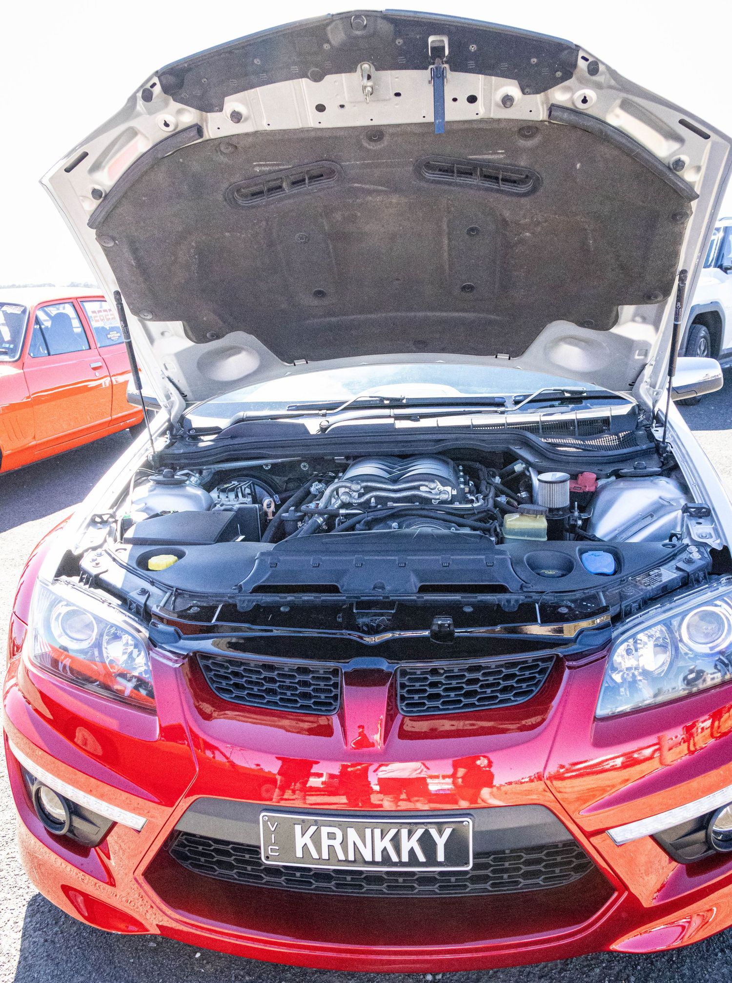 Red Holden with bonnet open showing engine detail at Ballarat drags