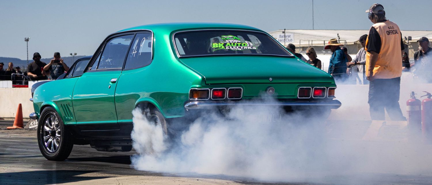 Green drag car launching with smoke at motorsport event Victoria