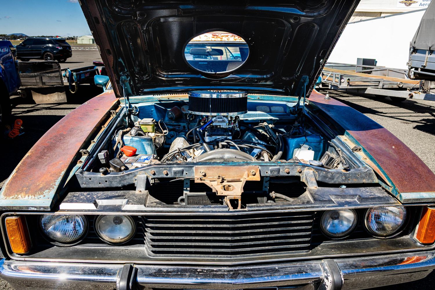 Engine bay detail of classic car with bonnet open at track day