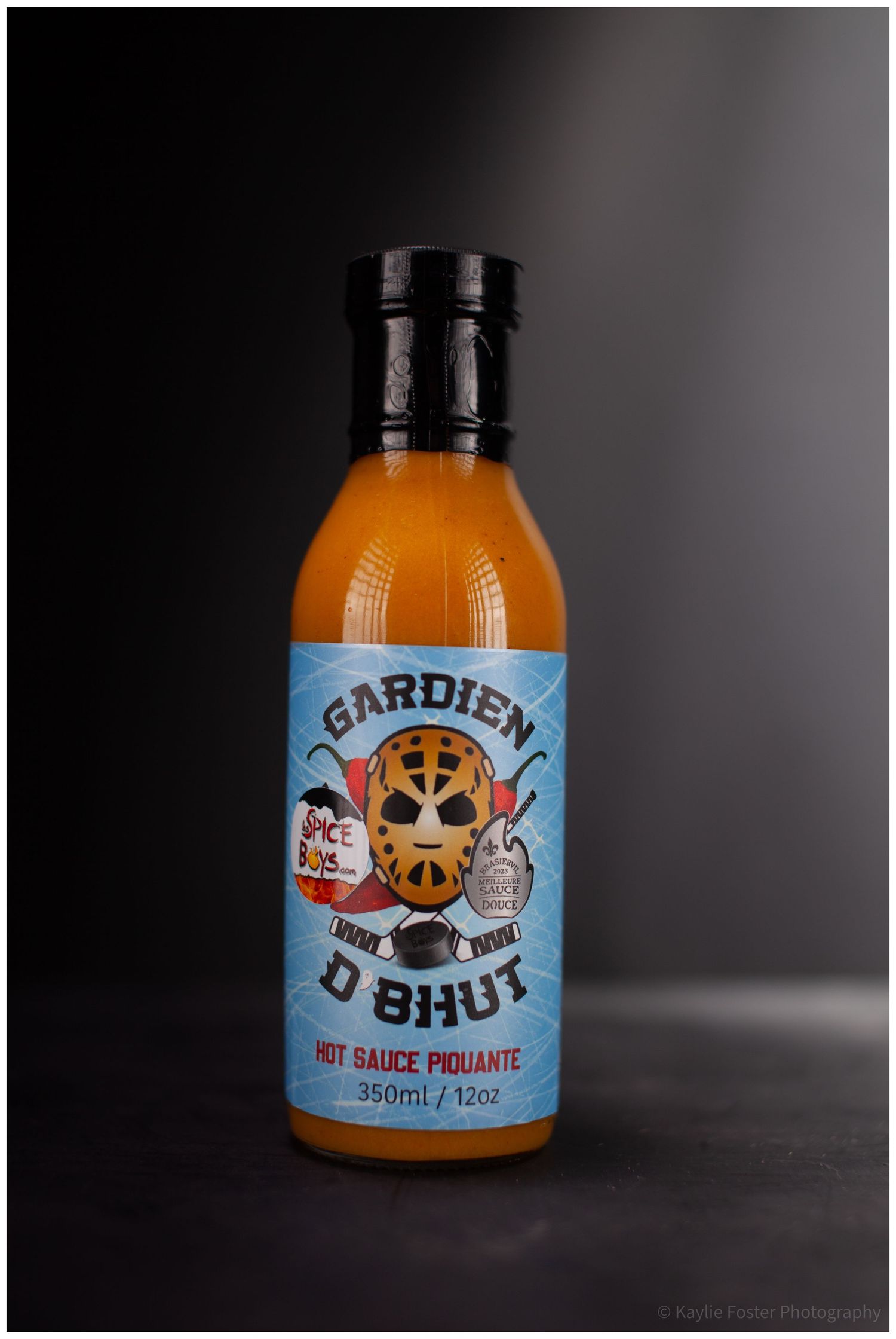 Gardien D Bhut hot sauce piquante 350ml bottle with blue hockey-themed label on dark background.