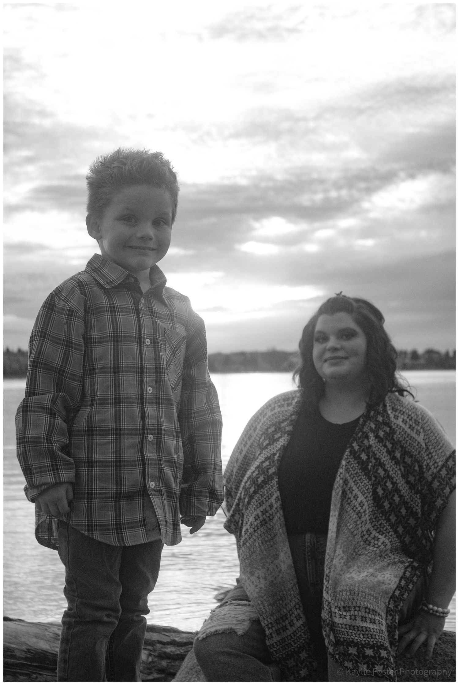 Black and white portrait of boy and girl holding hands by a lake.